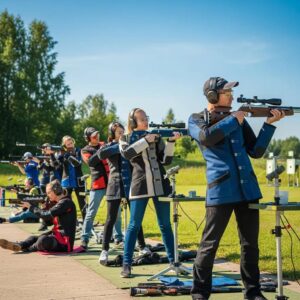 Group of air rifle shooters at a range, showcasing safety gear and rifles